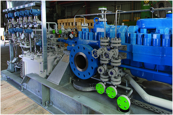 Blue industrial pump with valves and piping
